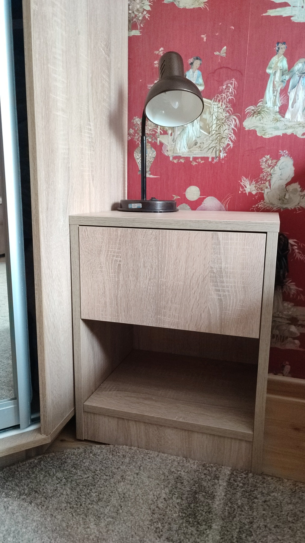 Sonoma oak Hiddo nightstand with a drawer and open lower shelf beside a lamp