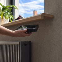 B01 hidden storage box with smartphone shown under a wooden shelf in a modern interior