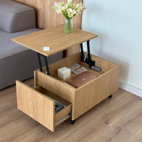 A light wood rolling storage ottoman table with a lift-top mechanism and two drawers, shown in a home setting with a sofa, wooden floor, and flowers on top.