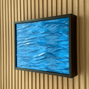 Hidden Wall Storage with Contactless RFID Lock. A framed abstract blue artwork with a black frame, mounted on a light wood slatted wall.