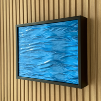 Hidden Wall Storage with Contactless RFID Lock. A framed abstract blue artwork with a black frame, mounted on a light wood slatted wall.