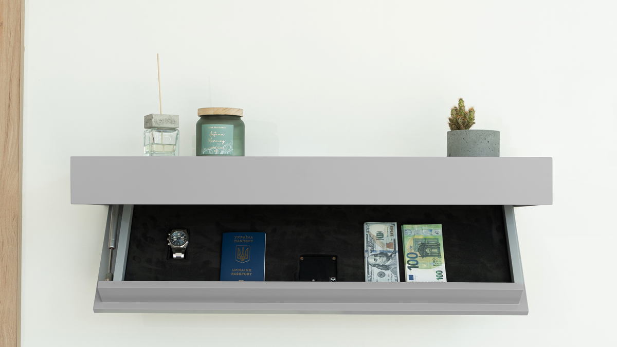 Open grey floating shelf revealing the hidden storage compartment