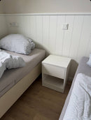 White Hiddo nightstand B28 with a drawer and open lower shelf between two beds