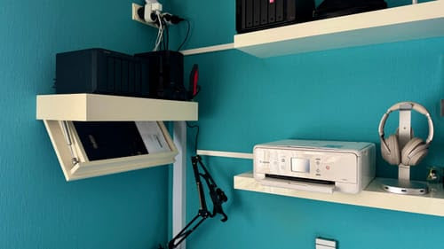 White Hiddo floating wall shelf with the hidden compartment open in a home office